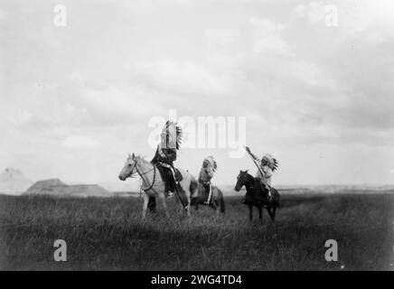 Der marsch der Sioux, 1905. Drei Sioux-Indianer zu Pferd auf Ebenen mit Felsformationen im Hintergrund. Stockfoto