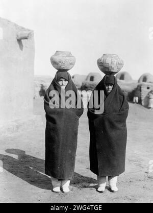 Zuni Wasserträger, c1903. Zwei Weibchen in voller Länge, mit Decken, Töpfen auf Köpfen. Stockfoto