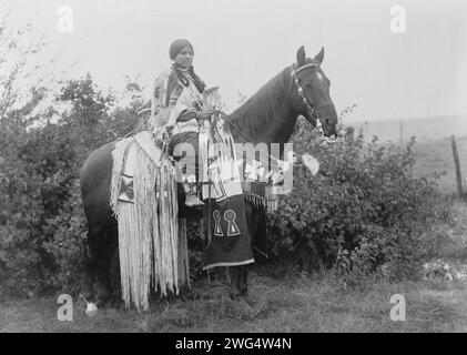 Feiertagsfänge, 1910. Cayuse-Frau zu Pferd, trägt ein Kleid aus perlenbesetztem Buckelleder; Pferd hat lange Pailletten und Perlen, Oregon. Stockfoto