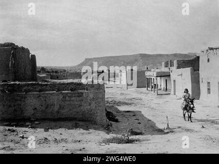 Eine Straßenszene in San Ildefonso Pueblo, 1905, 1905. San Ildefonso, New Mexico, zeigt Straßen und lehmziegelhäuser und einen Jungen, der auf einem Burro reitet. Stockfoto