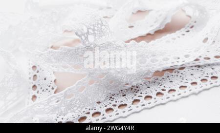 Weiches weißes Schnürband aus nächster Nähe auf braunem Papier. Stockfoto