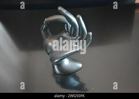 Eine handgeformte Statuette aus mattschwarzer Keramik befindet sich auf einem mattschwarzen Hintergrund. Stockfoto