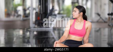 Eine junge Frau nimmt einen achtsamen Moment in ihrem Turntraining. Stockfoto
