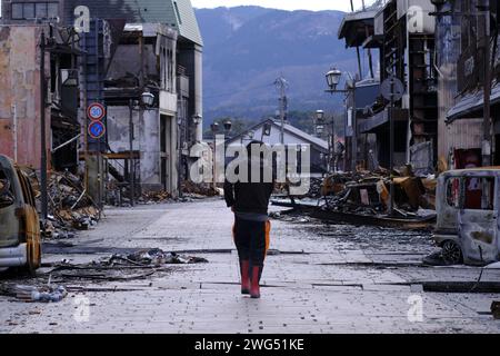 Ein Mann, der in der Asaichi Street (Wajima City, Präfektur Ishikawa) einen Monat nach der Zerstörung durch ein Feuer auf der Halbinsel Noto zu sehen war. Takashi Matsumoto, 36, wandert durch die Straßen und sucht nach Erinnerungsstücken an seine Eltern, die zu Tode verbrannt sind. Ein Erdbeben der Stärke 7,6 traf Zentraljapan am Neujahrstag. Ein Monat ist seit dem Erdbeben auf der Halbinsel Noto vergangen, und die Szene ist immer noch so tragisch wie unmittelbar nach der Katastrophe. Der Wajima Asaichi Markt im Zentrum von Wajima City in der Präfektur Ishikawa wurde durch einen massiven Brand zerstört, der sich auf mehr als 200 Gebäude A ausbreitete Stockfoto