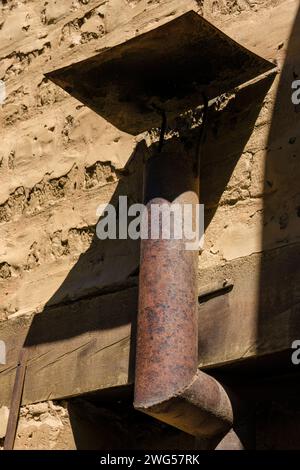 Der rostige eiserne Kamin für einen Gas-Warmwasserbereiter, beleuchtet von der Morgensonne, auf einem Bauernhof in der Nähe der Kolonialstadt Villa de Leyva in Zentral-Kolumbien Stockfoto