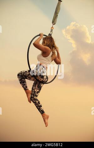 Aktive Frau mittleren Alters, die im Freien auf einem Luftkorb auftritt Stockfoto