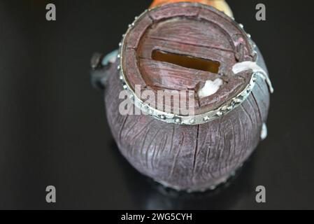 Keramikstatuette, eine Schweinebank für Geld in Form eines Hundes, der aus einer Kabine blickt, in Form eines Fasses mit Bier unter schwarzer glänzender Oberfläche. Stockfoto