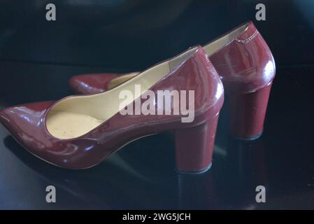 Der reine modische Stil, dunkle Kirschlackschuhe mit spitzer Spitze, Damenschuhe mit Absatzschuhen aus echtem Leder. Stockfoto
