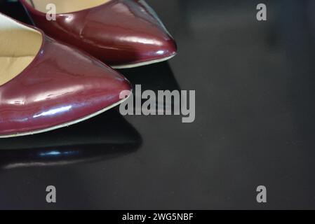Der reine modische Stil, dunkle Kirschlackschuhe mit spitzer Spitze, Damenschuhe mit Absatzschuhen aus echtem Leder. Stockfoto