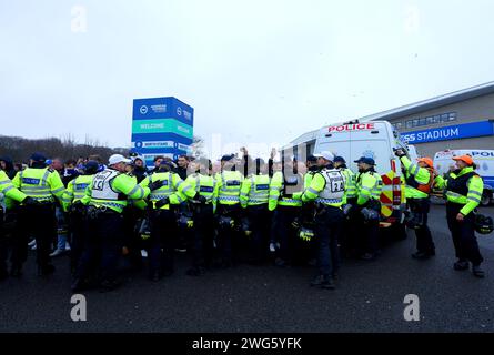 Polizisten halten Brighton und Hove Albion Fans vor dem Spiel der Premier League im American Express Stadium in Brighton zurück. Bilddatum: Samstag, 3. Februar 2024. Stockfoto