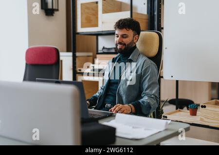 Ein Mann im modernen Büro, der an seinem Laptop arbeitet, mit effizienter Arbeit und einem Hauch von Coolness durch die digitale Landschaft navigiert. Stockfoto