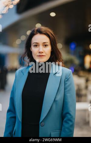 Selbstbewusste Geschäftsfrau im stylischen blauen Blazer-Outdoorporträt. Stockfoto