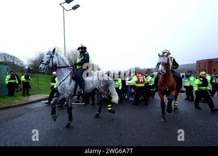 Polizeibeamte begleiten Fans vor dem Spiel der Premier League im American Express Stadium in Brighton zum Stadion. Bilddatum: Samstag, 3. Februar 2024. Stockfoto