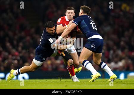 Josh Adams (Mitte) wird von den schottischen Sione Tuipulotu (links) und Huw Jones während des Guinness Six Nations Matches im Principality Stadium in Cardiff angegriffen. Bilddatum: Samstag, 3. Februar 2024. Stockfoto