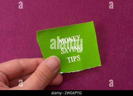 Tipps zum Einsparen von Geld auf gerissenem Papier mit farbigem Hintergrund. Konzeptionelles Geschäftssymbol. Draufsicht, Kopierraum. Stockfoto