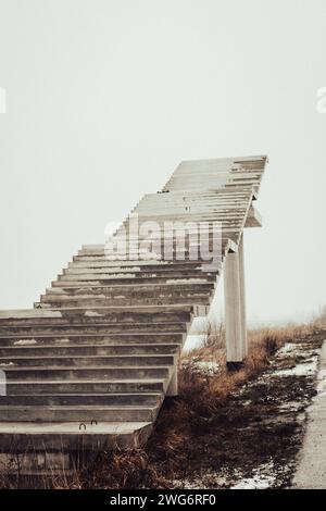 Treppen ins Nirgendwo. Leere unfertige Bridge. Außentreppe ohne Ende Treppe zum Himmel. Brücke im Bau. Treppen gegen bewölkten Himmel Stockfoto