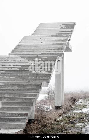 Treppen ins Nirgendwo. Leere unfertige Bridge. Außentreppe ohne Ende Treppe zum Himmel. Brücke im Bau. Treppen gegen bewölkten Himmel Stockfoto