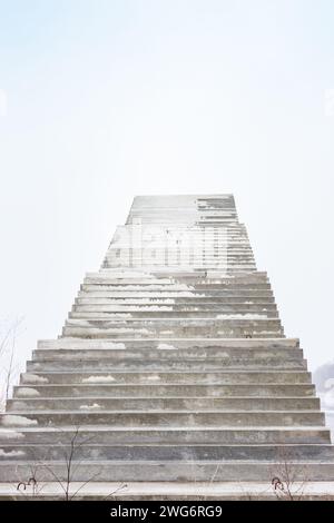 Treppen ins Nirgendwo. Leere unfertige Bridge. Außentreppe ohne Ende Treppe zum Himmel. Brücke im Bau. Treppen gegen bewölkten Himmel Stockfoto