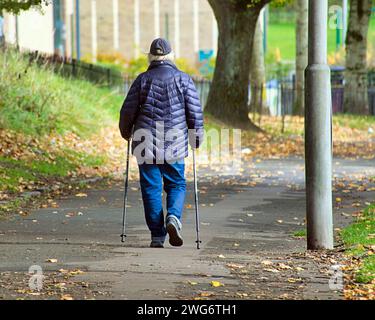 Glasgow, Schottland, Großbritannien. Februar 2024. Wetter in Großbritannien: Ein langweiliger Tag sah Einheimische auf den Straßen des Stadtzentrums. Ein alter Mensch spaziert mit Wanderstöcken. Credit Gerard Ferry/Alamy Live News Stockfoto