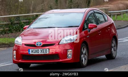 Milton Keynes, UK-Feb 3rd 2024: 2010 rotes Toyota Prius Hybrid-Elektroauto, das auf einer englischen Straße fährt. Stockfoto