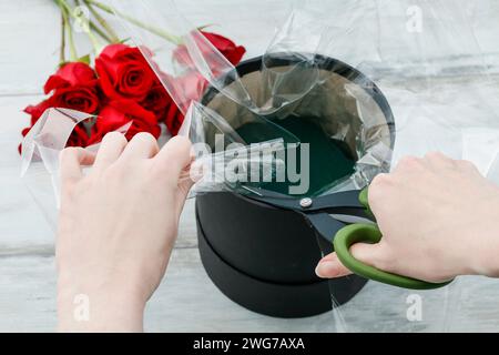 Blumengeschäft am Arbeitsplatz: Wie erstelle ich box mit Blumen, Schritt für Schritt Anleitung. Vorschlag oder Hochzeit Geschenk-Idee. Stockfoto