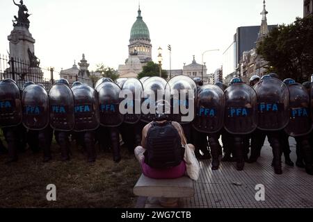 Buenos Aires, Argentinien. Februar 2024. Eine Frau setzt sich während der Demonstration vor Sicherheitskräften. Tausende Argentinier gingen am Tag einer Debatte auf die Straßen von Buenos Aires, um gegen den Gesetzesentwurf des argentinischen Präsidenten Javier Milei zu protestieren, der im Nationalkongress als "Omnibus-Gesetz" bekannt ist. (Foto: Mariana Nedelcu/SOPA Images/SIPA USA) Credit: SIPA USA/Alamy Live News Stockfoto