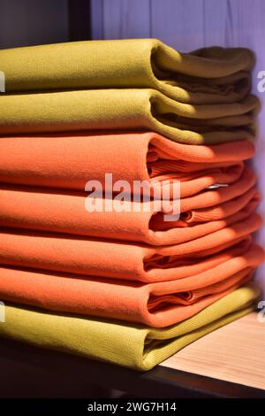 Stapel bunte Kleidung in einer Boutique. Merchendising Bekleidungsgeschäft. Stockfoto