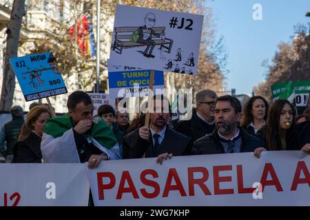 Madrid, Spanien. Februar 2024. Ein Mann hält ein Plakat mit Karikaturen während einer Demonstration, die durch die Straßen von Madrid führte, die von Anwälten und Anwälten aus verschiedenen Verbänden und Gruppen in Spanien gerufen wurde und einen fairen Ruhestand und einen angemessenen Rechtsbeistand forderte. Quelle: SOPA Images Limited/Alamy Live News Stockfoto