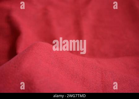 Roter femininer palatin, werkseitig gefertigter, warmer, weicher Stoff, sehr heller, satter Hintergrund mit Wellen. Stockfoto