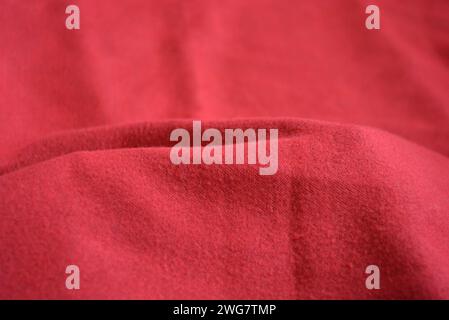 Roter femininer palatin, werkseitig gefertigter, warmer, weicher Stoff, sehr heller, satter Hintergrund mit Wellen. Stockfoto