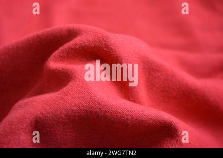 Roter femininer palatin, werkseitig gefertigter, warmer, weicher Stoff, sehr heller, satter Hintergrund mit Wellen. Stockfoto