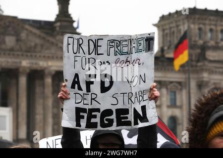 Berlin, Deutschland, 03.02.2024: Deutscher Bundestag: Demo gegen Rechtsextremismus von Netzwerk Hand in Hand , Menschenkette geplant: Demonstranten haben sich versammelt, eine Person hält ein Schild mit der Aufschrift für die Freiheit für das Leben, AfD von der Straße fegen , im Hintergrund das Reichstagsgebäude mit Deutschlandfahne *** Berlin, Deutschland, 03 02 2024 Demonstration des Deutschen Bundestages gegen Rechtsextremismus geplant von Hand in Hand Netzwerk , Menschenketten-Demonstranten haben sich versammelt, eine Person hält ein Schild mit der Aufschrift für Freiheit fürs Leben, fegt AfD von der Straße , in Stockfoto