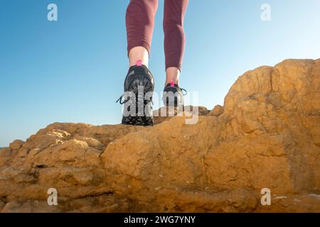 Nahaufnahme von Wanderschuhen, Wandern über Felsen auf einem Bergpfad Stockfoto