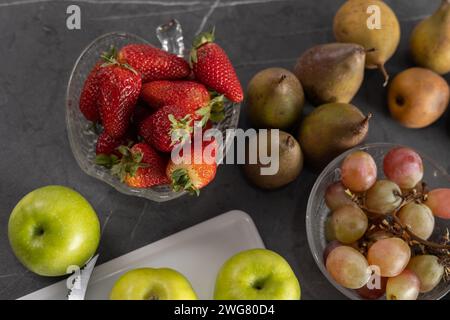 Obst im Studio, Tisch mit frischem Obst, Detail mit Äpfeln, Birnen, Erdbeeren, Wassermelone und Trauben, Zutaten für gesunde Ernährung, frisch Stockfoto