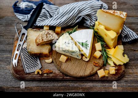 Käseplatte mit Nüssen auf Einem Holzbrett ist Ein köstlicher Imbiss Stockfoto