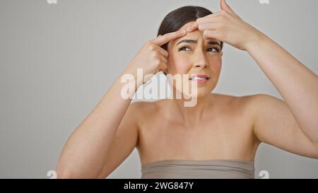 Junge schöne hispanische Frau, die Pickel über isolierten weißen Hintergrund wirft Stockfoto