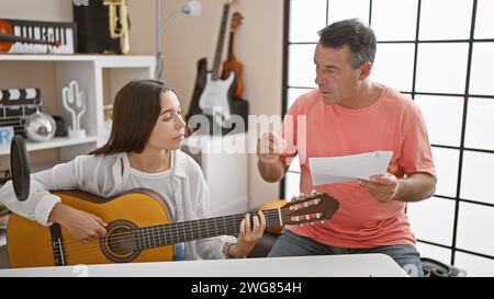 Hispanische Musiker erfreuen sich an einer klassischen Gitarrenmelodie in einem Musikstudio und konzentrieren sich in der ruhigen Atmosphäre voller Essenz von Stockfoto