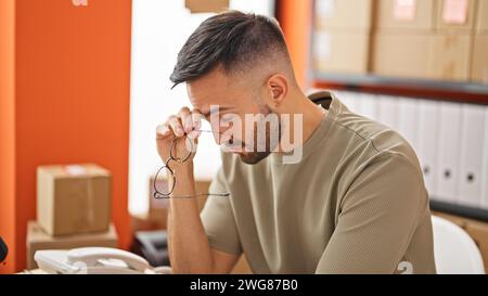 E-Commerce-Geschäft für junge hispanische Männer mit Brillen im Büro Stockfoto