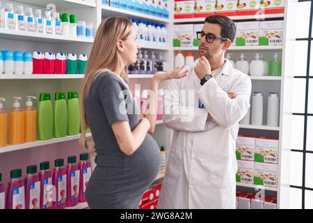 Mann und Frau Apotheker und schwangere Klientin in der Apotheke Stockfoto