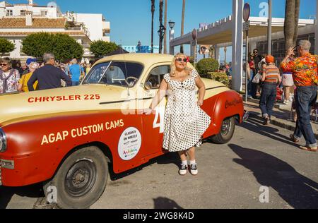 Eine Frau im Stil der 50er Jahre posierte vor einem alten Oldtimer beim Rockin Race Jamboree 2024, Rockabillies, Torremolinos, Andalusien, Spanien. Stockfoto