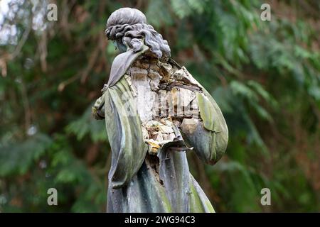 Typische Witterungs- und Frostschäden an alten Metallengelfiguren mit Gipskern aus dem Beginn des 20. Jahrhunderts auf einem historischen Friedhof Stockfoto