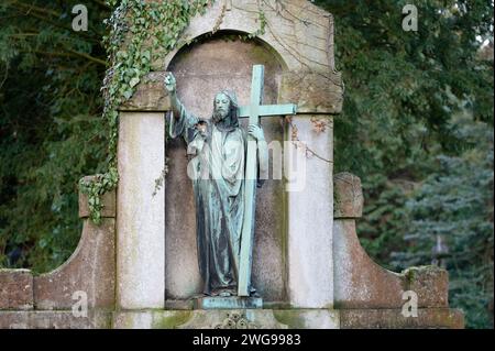 Statue jesu auf einem historischen Grab mit großem Kreuz und ausgerückter Hand zum Himmel Stockfoto