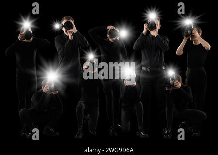 Gruppe von Fotografen mit Kameras auf schwarzem Hintergrund. Paparazzi machen Bilder mit Blitzen Stockfoto