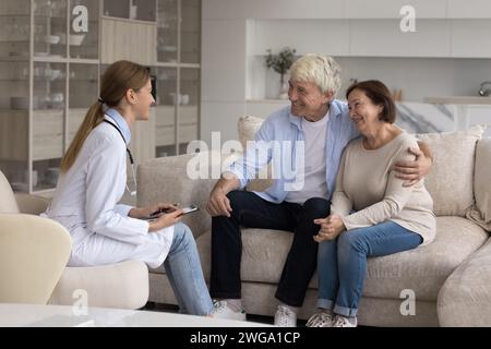 Junger Arzt besucht glückliches reifes älteres Patientenpaar Stockfoto