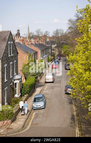 YORK, Großbritannien - 17. April 2023. Ein älteres Ehepaar, das eine Wohnstraße in einem historischen Vorort von York, Großbritannien, entlangläuft Stockfoto