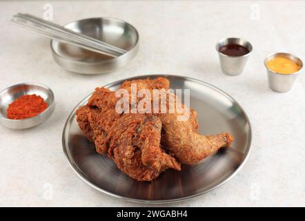 Koreanisch gebratenes ganzes knuspriges Hühnchen oder Style Market tiefgebratenes Sijang Tongdak. Serviert mit verschiedenen Sauce und Chili-Flakes Stockfoto