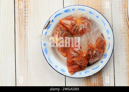 Indonesisches Sambal Street Food Beilage verpackt auf Kunststoff, Liefernahrungskonzept. Draufsicht Stockfoto