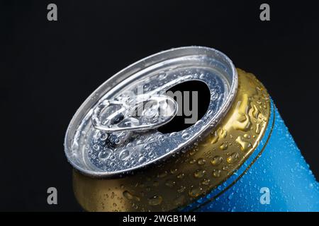 Aluminiumdose mit Wassertropfen auf dunklem Hintergrund bedeckt. Stockfoto