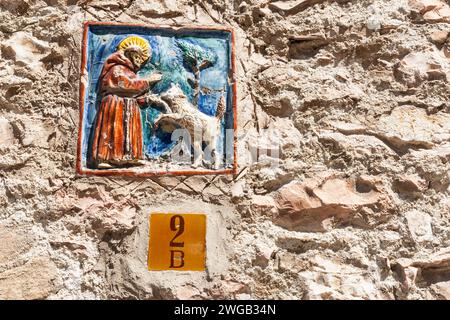 Assissi Italien 18. Mai 2011; Gedenktafel an der Außenmauer an der Straße mit Keramikbild des hl. Frances von Assissi, Schutzpatron der Tiere Stockfoto