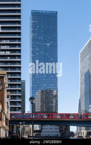 Der DLR Docklands Light Railway-Zug überquert die Brücke über das South Dock mit den Wolkenkratzern der Canary Wharf in East London, England, Großbritannien Stockfoto